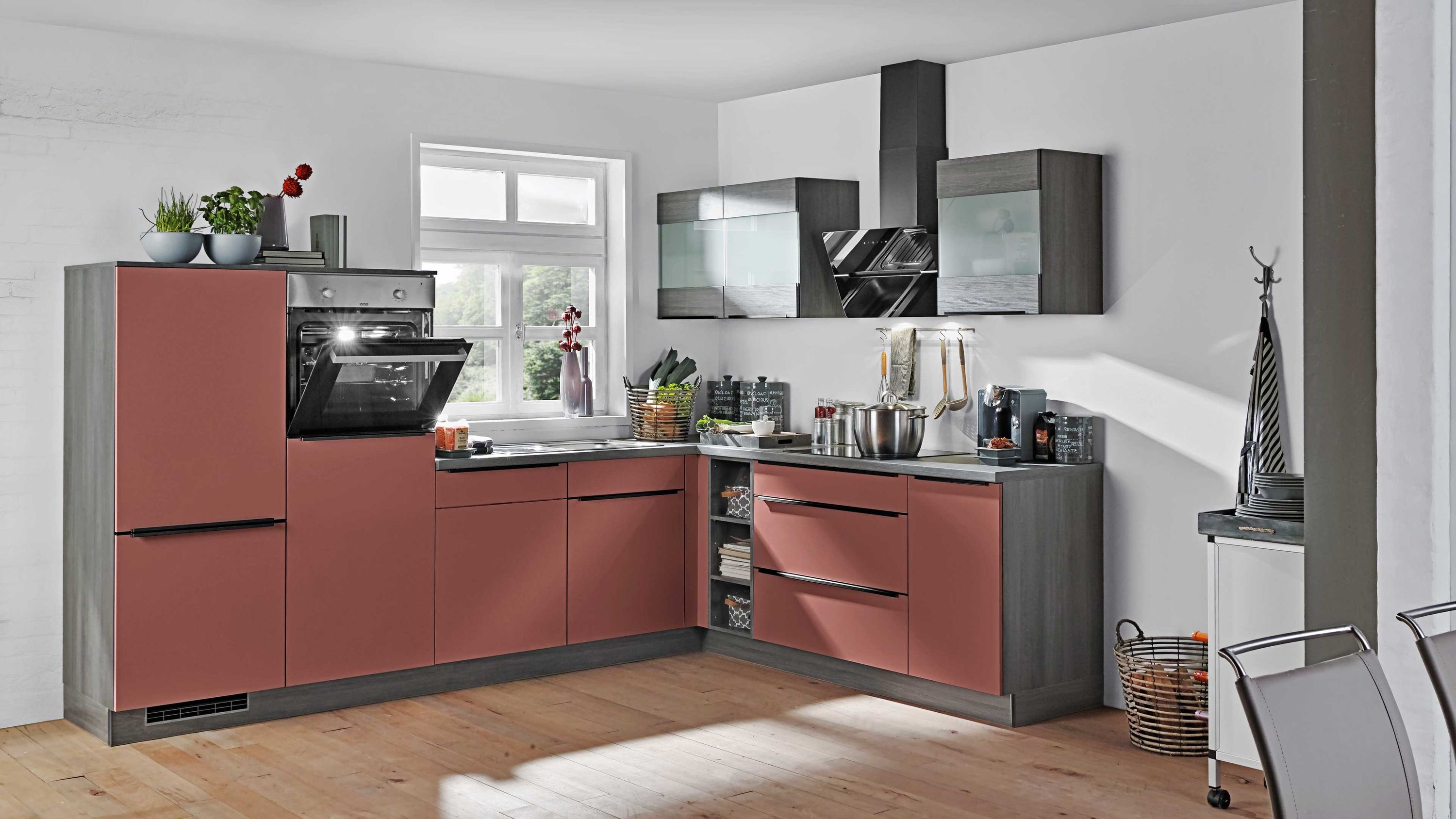 Moderne Winkelküche in Rot-Grau mit schwarzen Hängeschränken und Einbaugeräten.