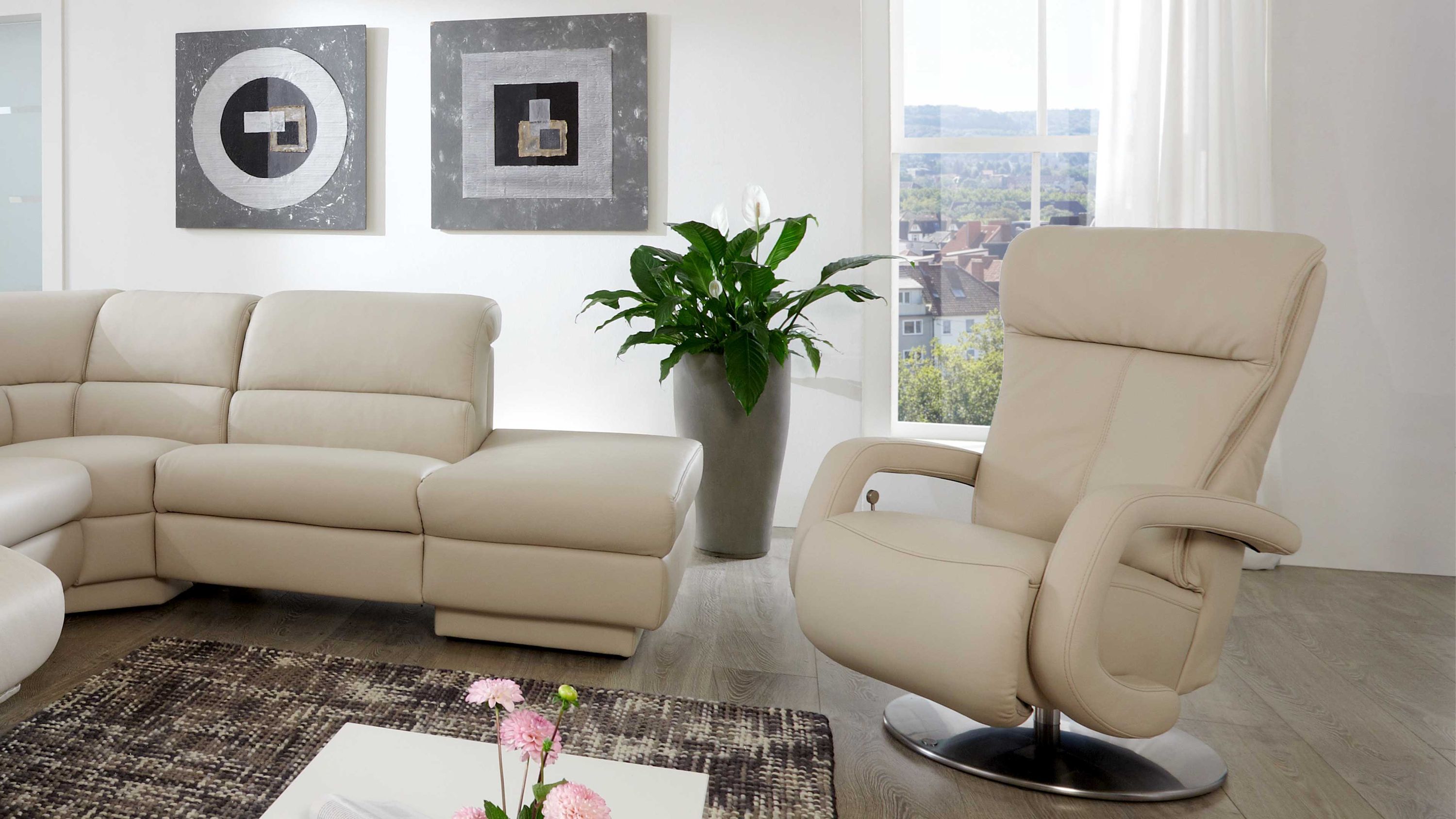Beiger Sessel mit hoher Rückenlehne und Metall-Tellerfuß in modernem Wohnzimmer