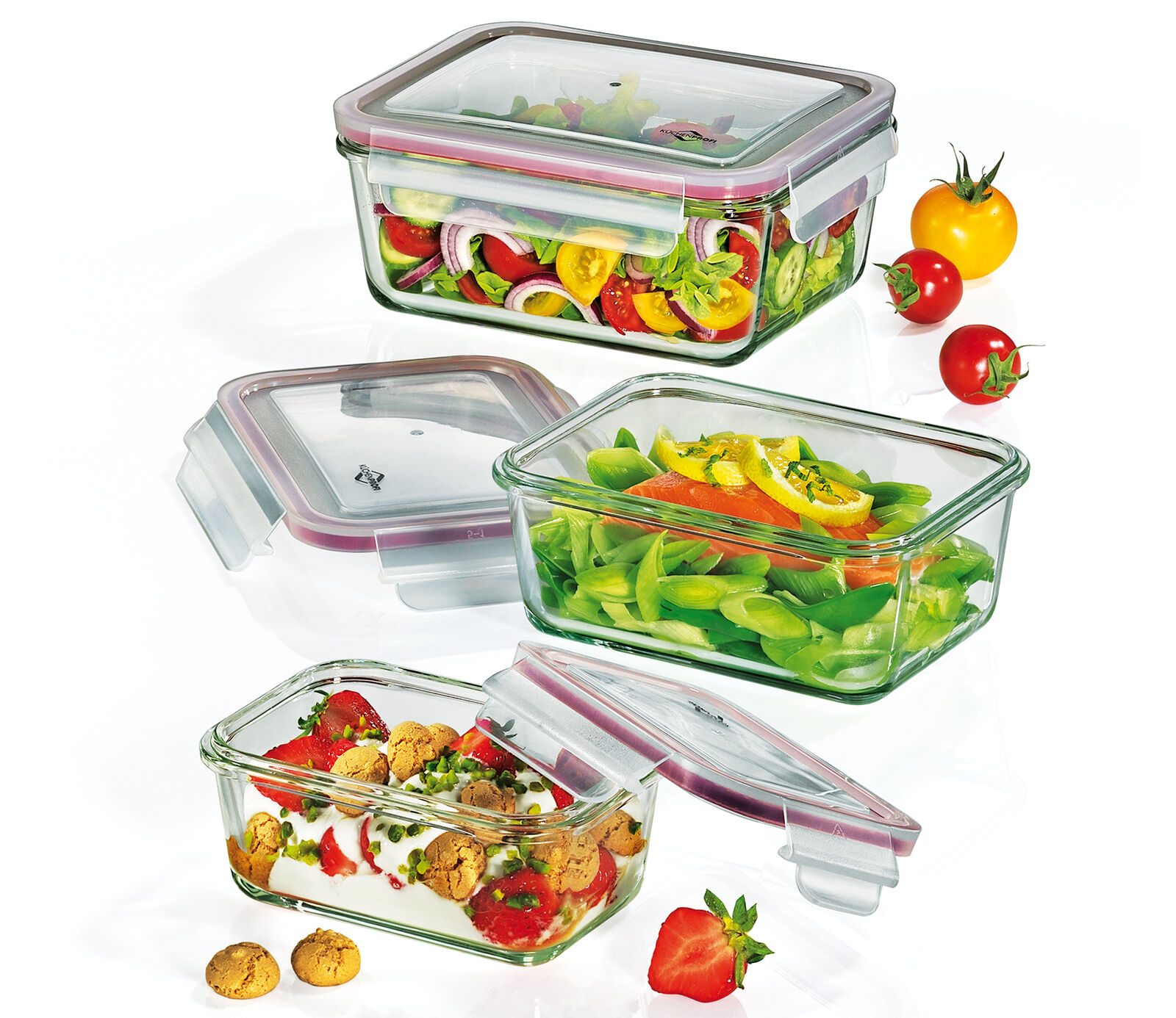 Dreiteiliges Vorratsdosen-Set aus transparentem Glas mit Deckeln  gefüllt mit frischem Obst und Gemüse