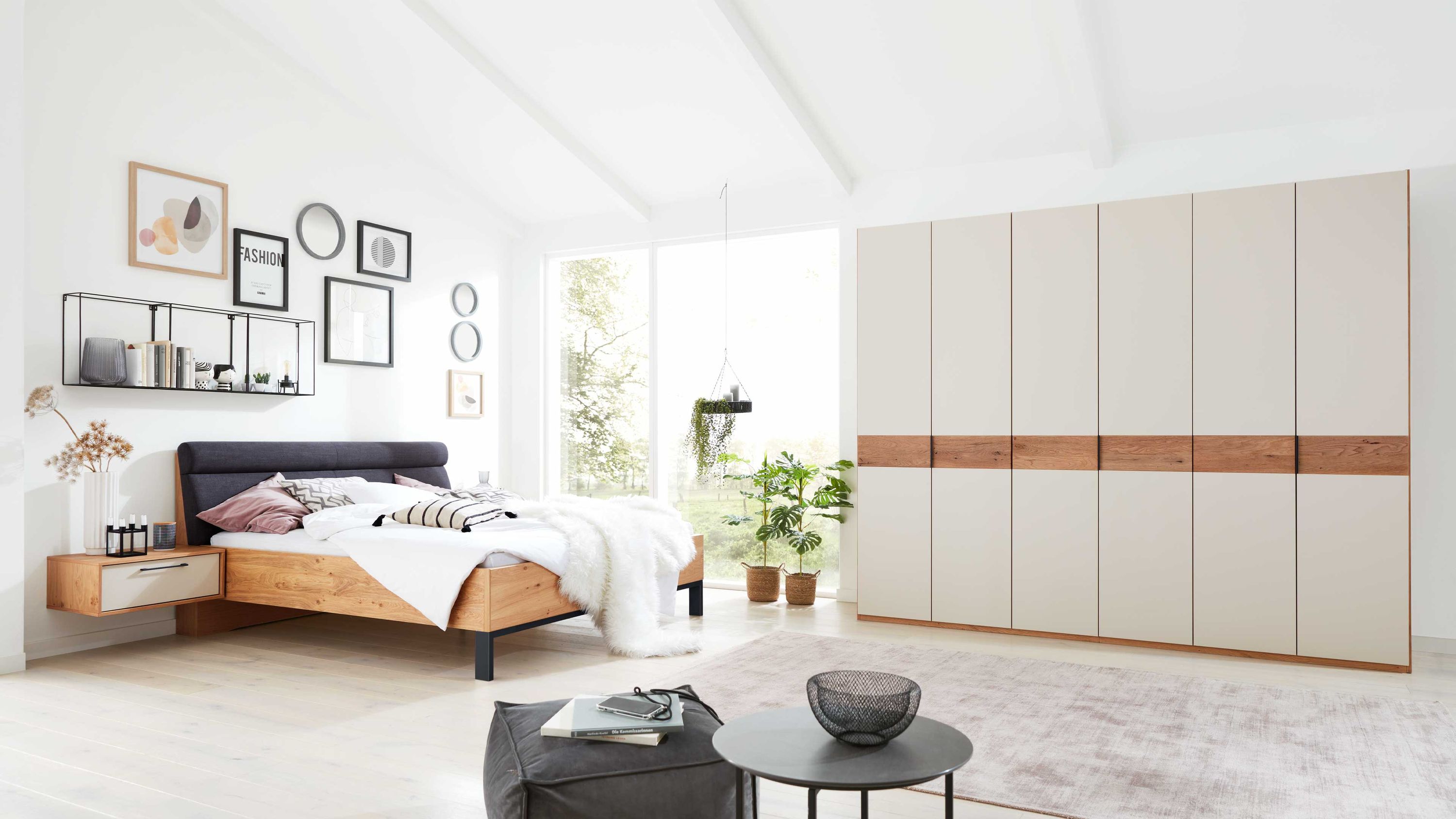 Schlafzimmer mit Kleiderschrank und Holzbett Schlafzimmer mit weißem Kleiderschrank und Holzbett mit schwarzem Kopfteil und schwebendem Nachttisch