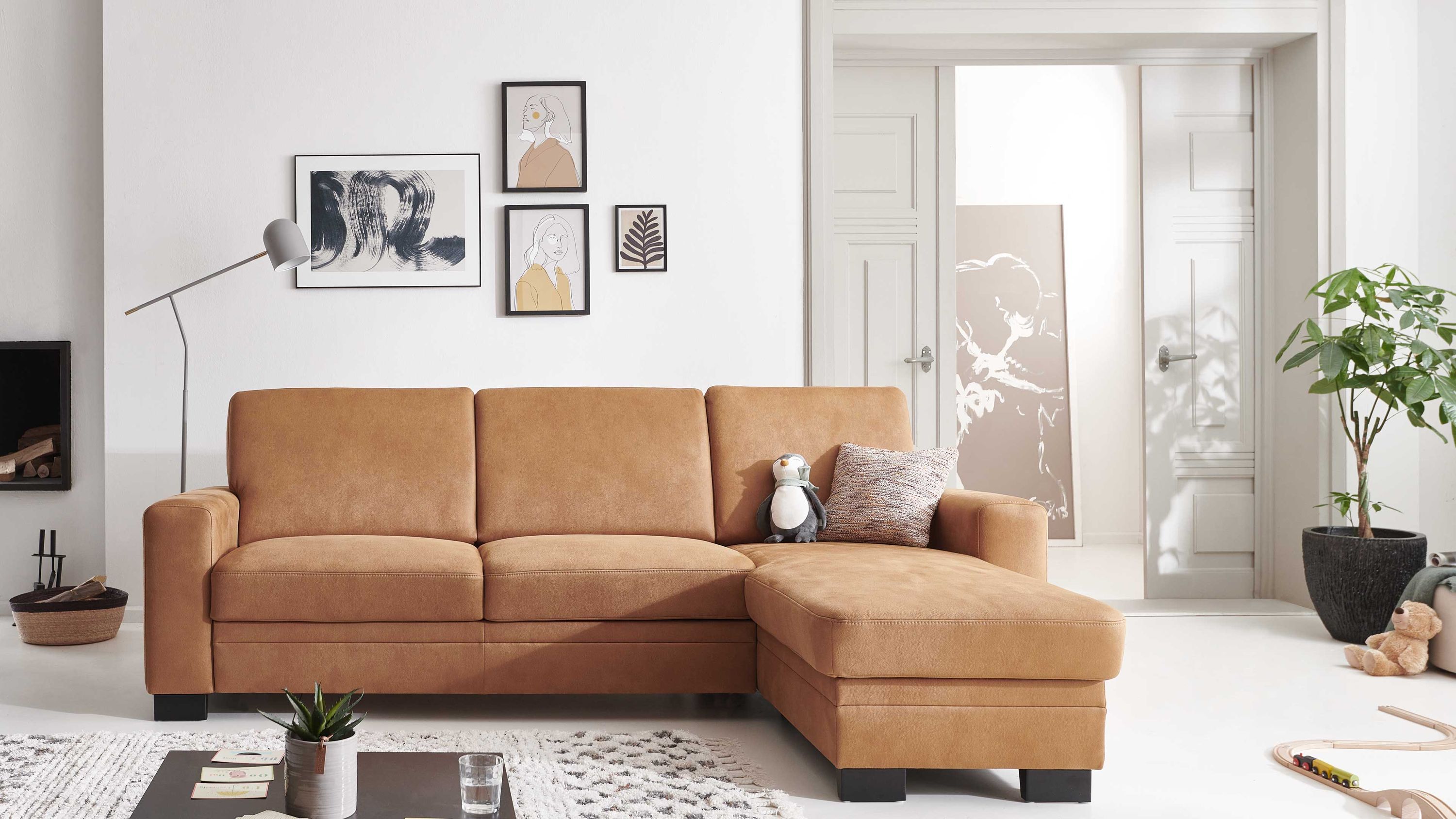Ecksofa mit drei Sitzpolstern und rechter Ottomane in zimtfarbener Mikrofaser mit schwarzen Metallfüßen im Wohnzimmer