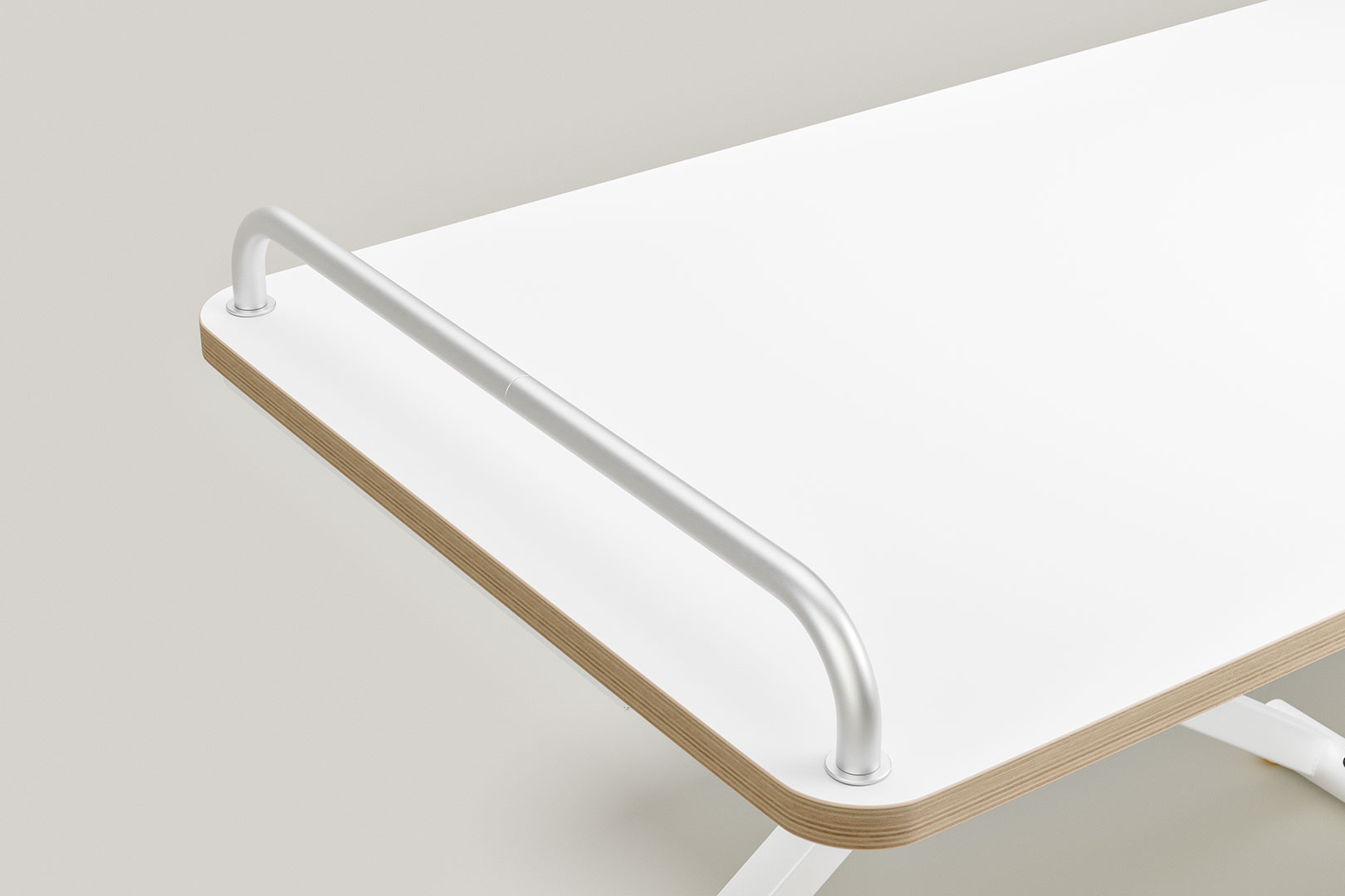 Aluminium-Stange, gebogen und an der Kante eines weißen Tisches befestigt.