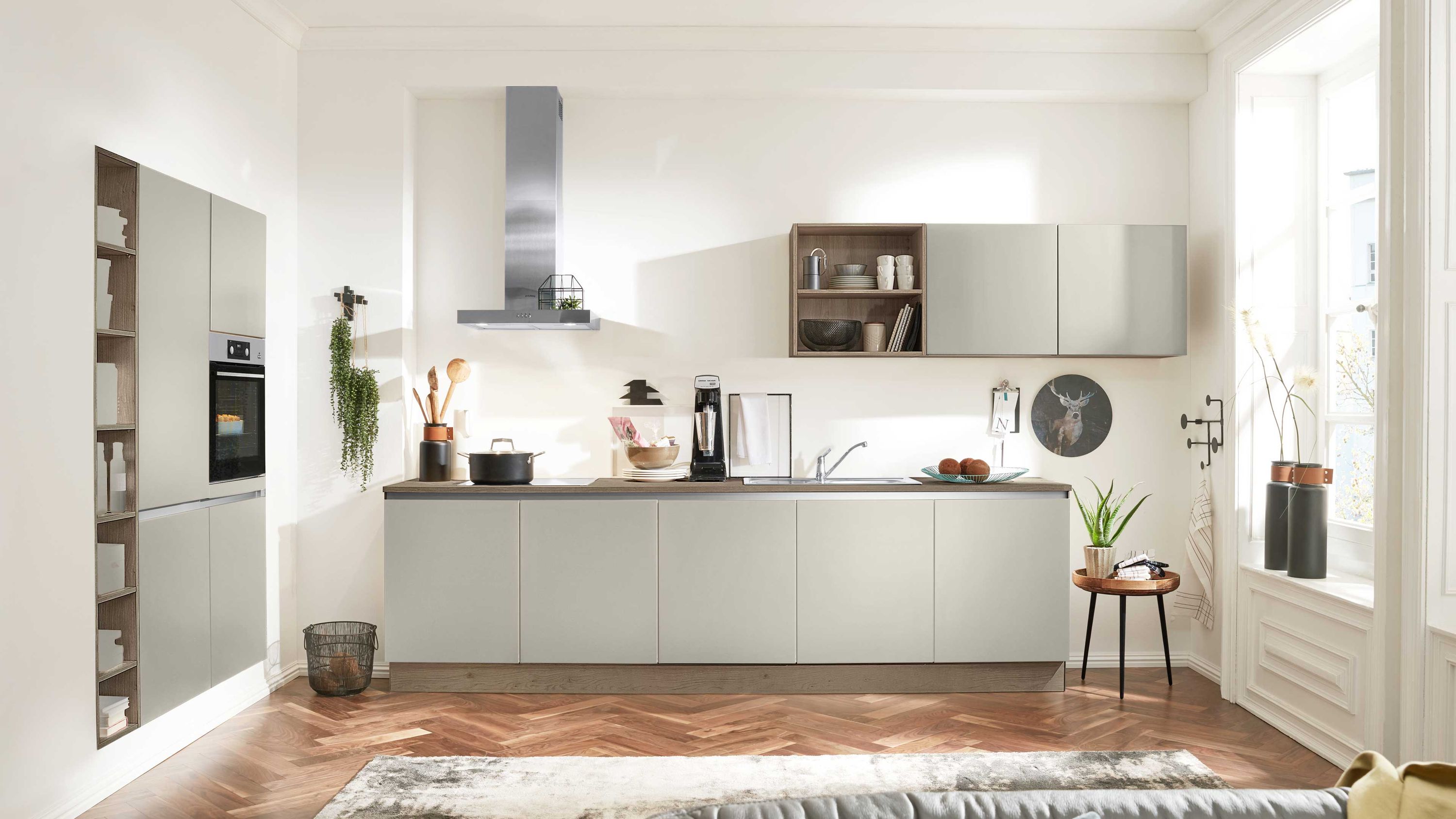 Graue Schränke Holzfußboden mit Teppich Einbauofen Fensterlicht Pflanzen und Küchenaccessoires