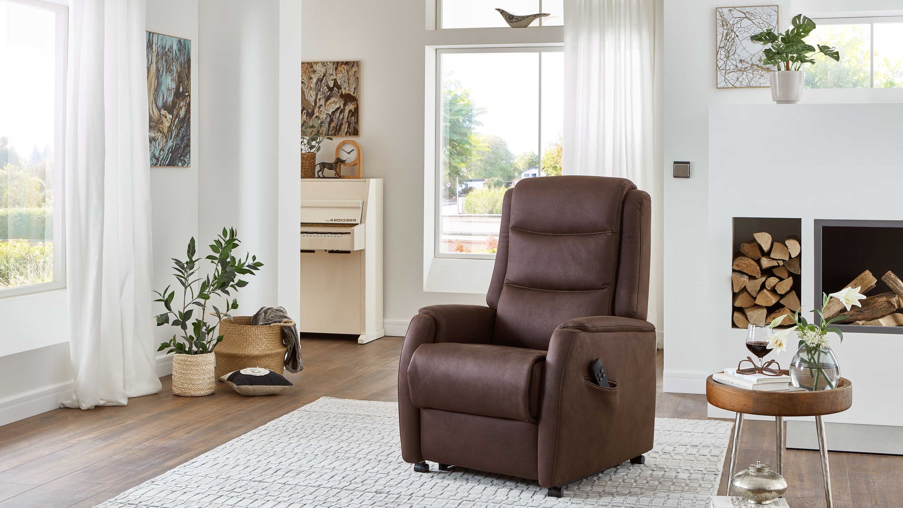 Espressofarbener TV-Sessel mit hoher Rückenlehne und gepolsterten Armlehnen in einem hellen Wohnzimmer